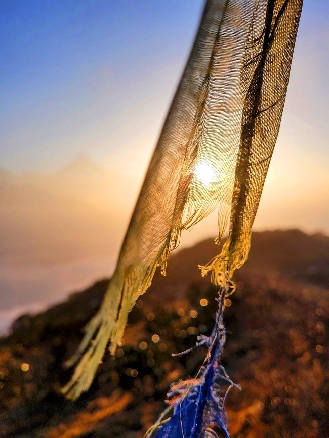 Sonnenaufgang am Poon Hill mit Gebetsfahnen im Vordergrund
